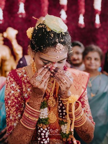An emotional moment for the bride during the ceremony, her hands covering her face in a gesture of overwhelming joy and reverence.