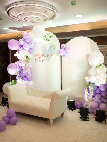 Celebrating a new arrival with style. This baby shower setup features a beautiful balloon and floral backdrop, creating a perfect, dreamy space for the parents-to-be.