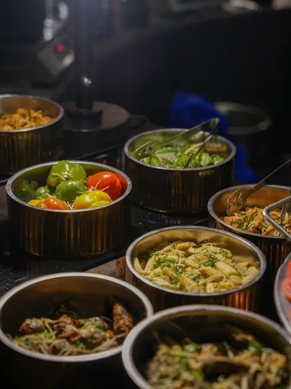 A selection of pasta salads and grilled vegetables, ready to be served. These dishes provide delicious and refreshing options for guests.
