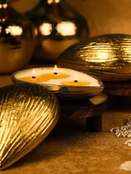 This is my almond-shaped urli candle, crafted from aluminum with a golden finish. When lit, the three wicks create a warm glow that highlights the intricate texture of the container.