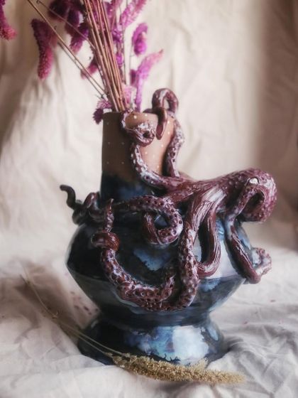 The octopus appears to be guarding the vase, its tentacles reaching up towards the opening. This piece tells a story of the mysterious and beautiful world that lives beneath the waves.