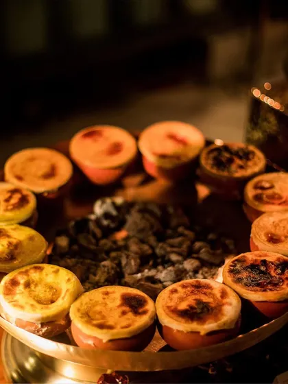 Individual portions of a rich, baked dish, served in traditional earthenware. This presentation style adds an authentic and rustic touch to the dining experience.