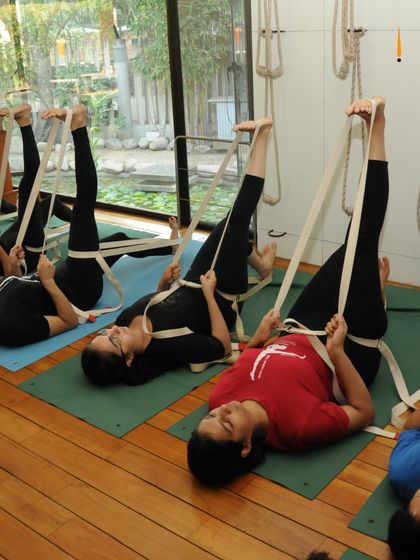 Students using belts for leg stretches. This is a common sight in my classes, as we focus on building a strong and flexible foundation.