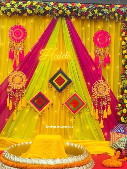 This Haldi backdrop uses colorful drapes, dreamcatchers, and phulkari-style elements to create a vibrant, folk-inspired theme.