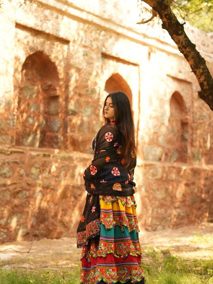 A back profile, showing the flow of the lehenga and the beautiful setting at Hauz Khas fort.