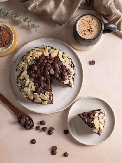 A cozy, chocolatey mood is perfect for a rainy day. This top-down shot of an almond chocolate cake is styled to feel comforting and absolutely irresistible, making you crave a slice.