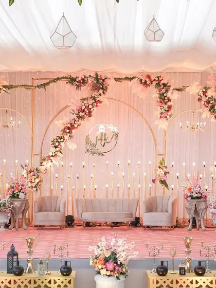 A regal reception stage in shades of pink, adorned with opulent chandeliers and candles. This setup is perfect for a couple looking for a majestic and elegant celebration.