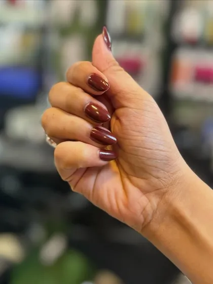 This manicure features a warm and sophisticated coffee mocha brown polish. The glossy finish on these almond-shaped nails makes it a perfect shade for any season.