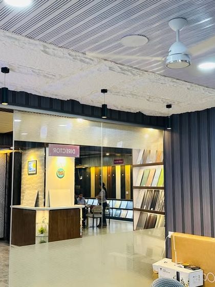 The entrance to our showroom features a combination of textured grey fluted panels and a decorative ceiling, giving you a taste of the modern designs we offer.