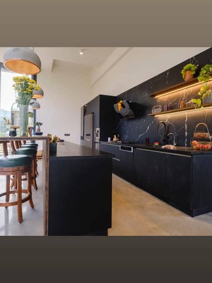 The open-plan kitchen in our Nandi Hills project features a sleek, monochromatic design with a black marble backsplash. The island doubles as a breakfast bar, making the kitchen a social hub with stunning views.