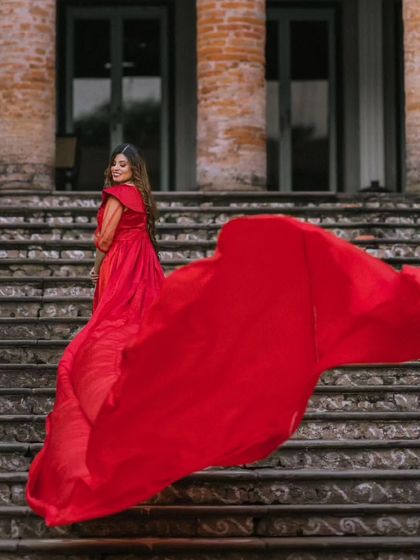 This gown offers two looks in one with its detachable sleeves. Here, the sheer sleeves add a touch of softness to the bold red, creating a dreamy look on the grand staircase.
