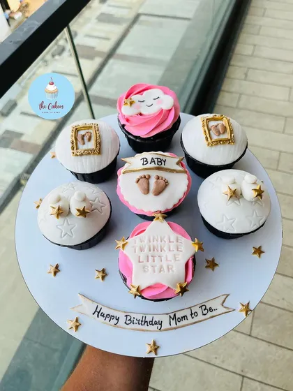 Celebrating a mom-to-be with a special set of baby shower cupcakes. This "Twinkle Twinkle Little Star" theme includes delicate details like tiny baby feet, framed sonogram pictures, and starry decorations, all handcrafted from fondant.