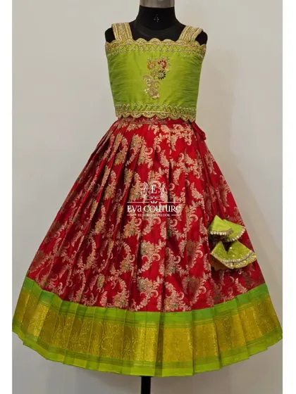 A festive red and lime green Banarasi lehenga. The sleeveless blouse has a scalloped, embroidered border, and the skirt is made of rich red brocade.