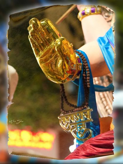 A close-up of the idol's hand in a gesture of blessing, a powerful symbol of the festival.