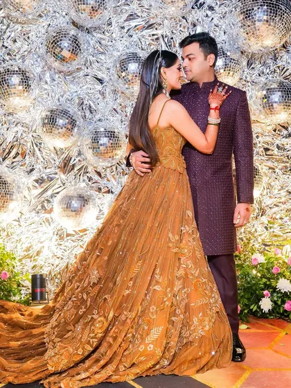 An intimate couple portrait against a backdrop of disco balls. This creative shot captures a romantic moment amidst the glitz and glamour of the sangeet night.