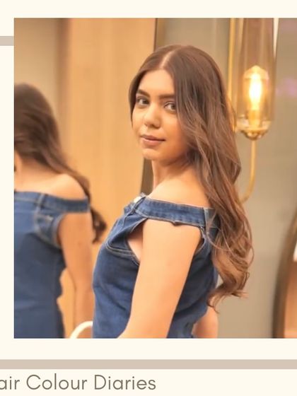 A client with soft, wavy hair and subtle brown highlights, looking over her shoulder. The lighting catches the different tones in her hair beautifully.