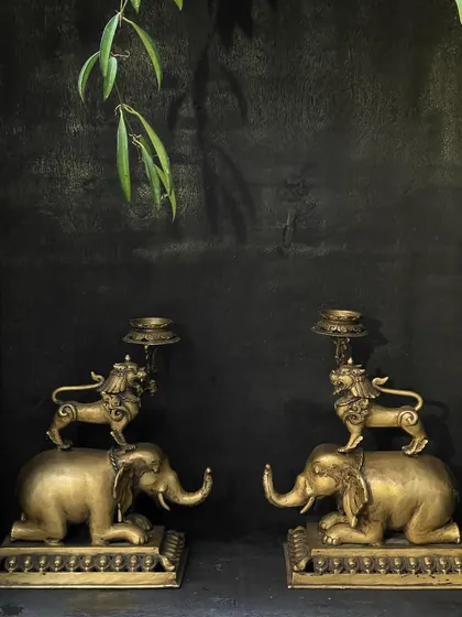 This pair of vintage brass candle stands, featuring a Tibetan-style lion on an elephant, adds a touch of Asian charm to any corner. The intricate craftsmanship tells a story of strength and majesty, perfect for creating an elegant focal point.