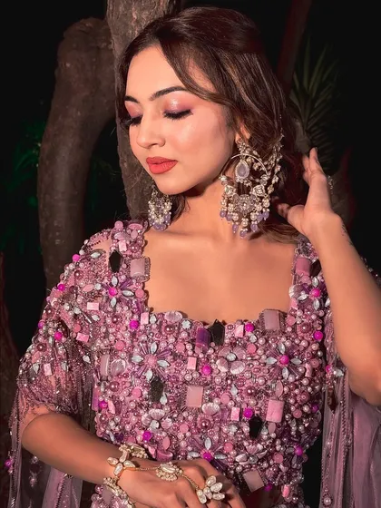 A close-up of the lavender Haldi look. The intricate jewelry and the soft, romantic makeup create a style that is both unique and beautiful.