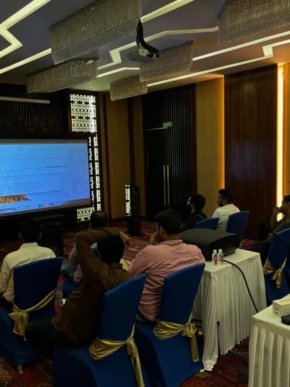 Attendees observe a live demonstration on a large projection screen, showing the immediate impact of calibration adjustments on the system's audio output. This visual feedback is essential for understanding complex acoustic concepts.