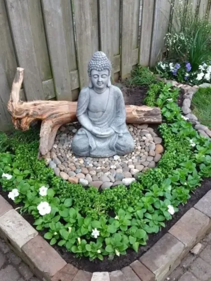 A compact Zen garden perfect for a small corner. I used a brick border to define the space, which features a Buddha statue, river pebbles, and low-growing flowering plants.