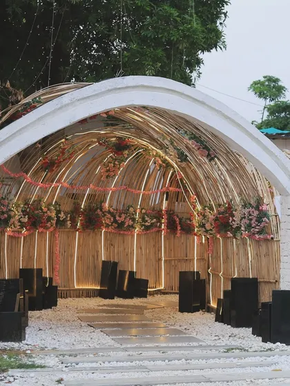 The bamboo archway decorated with flowers during the day. It looks just as beautiful in the sunlight, creating a charming entrance for daytime events.