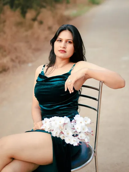 A seated portrait that is both daring and divine. The pose highlights the dress's high slit and the model's confident attitude.