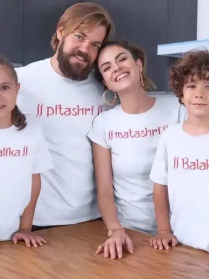 A traditional and sweet way to coordinate. This family chose matching white tees with "Pitashri," "Matashri," "Balak," and "Balika" prints for a classic family portrait.
