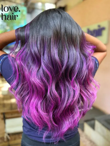 A back view of this purple and pink balayage, showcasing the expert blending and vibrant hues.