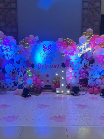 The blue and pink lighting adds a magical touch to the Minnie Mouse birthday setup, making the whole stage glow.