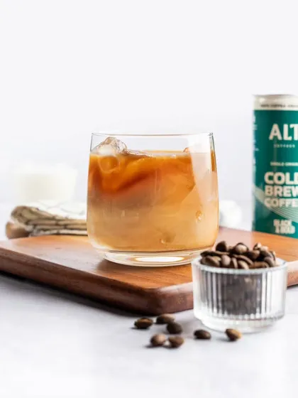 This close-up shot focuses on the beautiful gradient created when milk blends with cold brew coffee. The styling is simple and clean, letting the drink itself be the star.