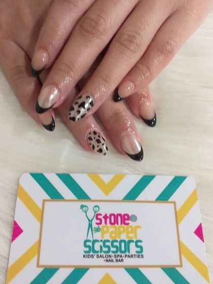This look combines a sleek black French tip with a bold leopard print accent nail. It's a great way to add a touch of wildness to a classic style.