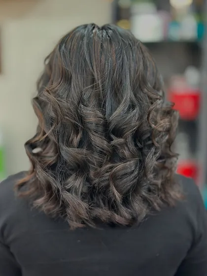 The back view of the copper light brown highlights, showing how the curls enhance the color and create a voluminous look.