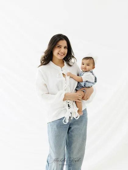 A casual and relaxed "mommy and me" portrait. The simple white shirts and jeans keep the focus on the natural, happy connection between this mother and her baby.