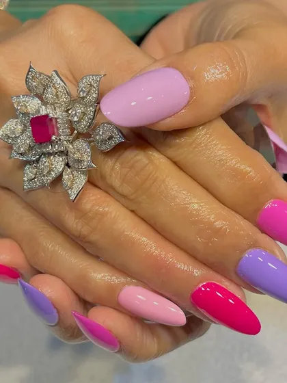 When pink meets purple, the magic happens. This vibrant set features different shades of pink and purple on long, stiletto nails for a bold and playful look.