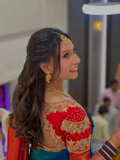 A side view of Shraddha's engagement hairstyle, showing the soft curls and elegant hair accessory.