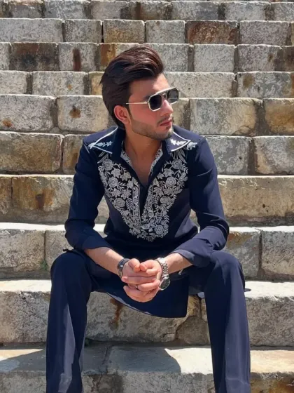 A navy blue kurta with a collared neckline and silver embroidery, paired with flared trousers for a retro vibe.