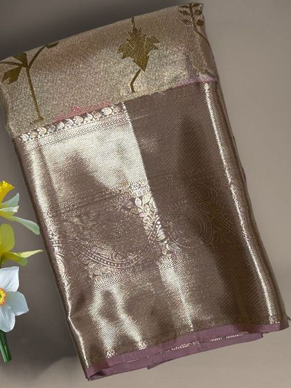 A close-up of a gold tissue Kanchi silk saree with leaf motifs.