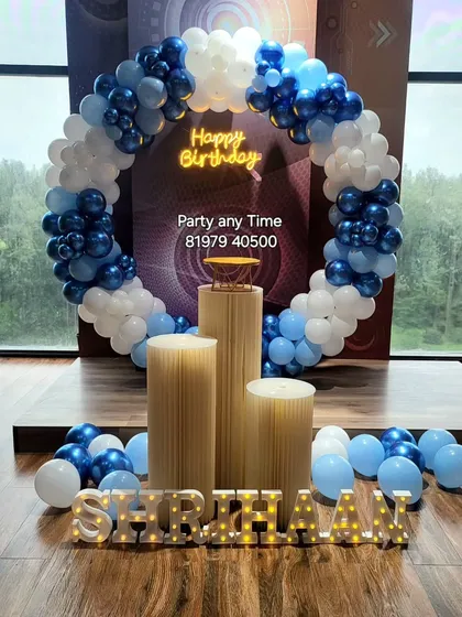 A blue and white circular balloon arch for a birthday celebration.