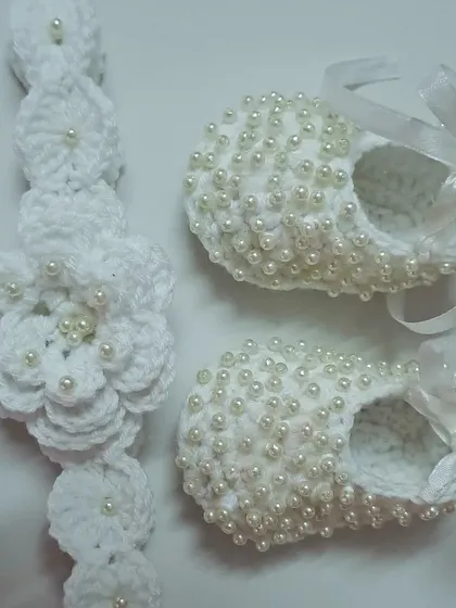 A different angle of the pearl-adorned booties and headband set, showing the intricate detail of the floral headband.