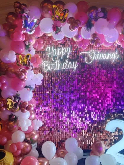 We love a bit of glam! This 21st birthday setup features a vibrant pink and rose gold balloon arch against a sparkling sequin wall, complete with a custom neon sign for that perfect party picture.
