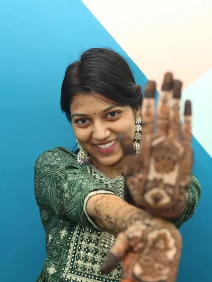 A playful pose by the bride, showing off her henna-adorned hands. We work with you to get a variety of shots for your mehandi photography, from candid to posed.