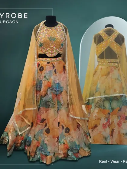 Unleash your inner grace with this dreamy yellow floral printed lehenga. The cross-back blouse adds a modern and stylish touch.
