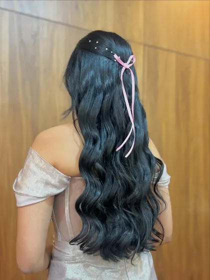 A romantic half-updo with a delicate pink ribbon and scattered crystals. Perfect for a modern fairytale look.
