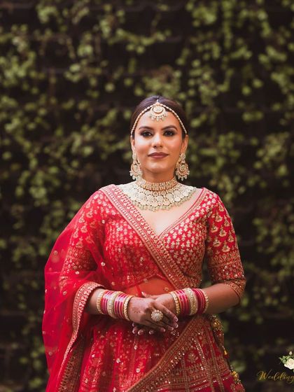 A classic bridal portrait. The makeup is all about luminous skin and softly defined eyes, creating a luxury finish that complements her statement jewelry.