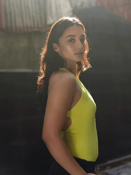 The backlighting in this shot emphasizes the dewy finish of the makeup and the healthy shine of the hair.