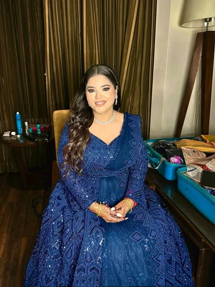 The complete look for this sangeet bride. The elegant blue gown is paired with soft makeup and classic waves, creating a timeless and sophisticated style.