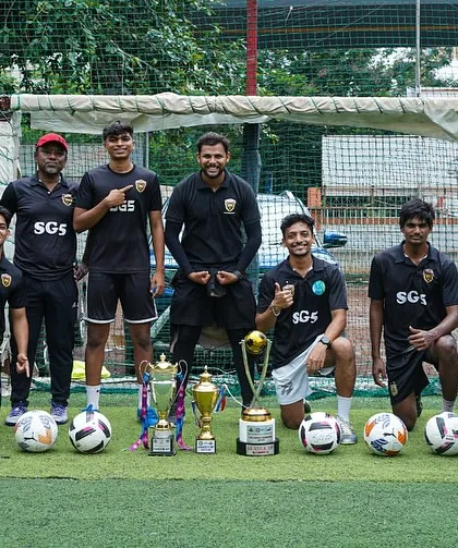 Our coaches posing with the tools of their trade: footballs and trophies. We are ready to train the next generation.