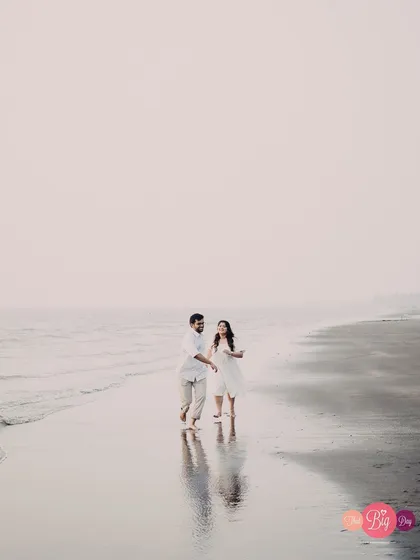 A walk to remember. The couple's reflection on the wet sand adds a dreamy, ethereal quality to this beach photograph.