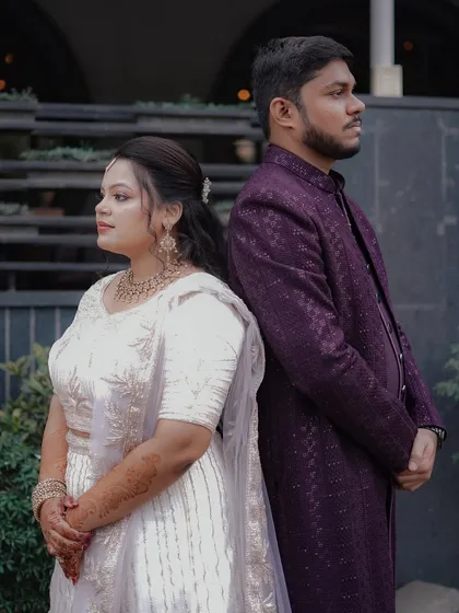 A stylish, posed back-to-back shot of the couple, showcasing their modern engagement attire.
