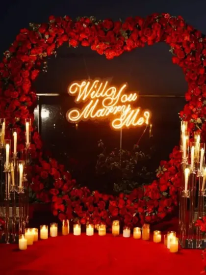 For a truly unforgettable proposal, I create dramatic and romantic backdrops like this one. A heart-shaped arch of red roses, a neon "Will You Marry Me?" sign, and dozens of candles create the perfect atmosphere for a yes.